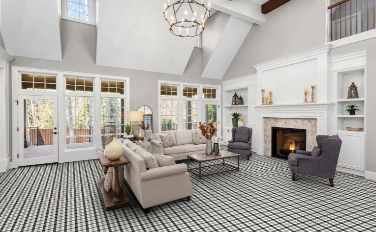 living room with cozy fire and plaid carpeting